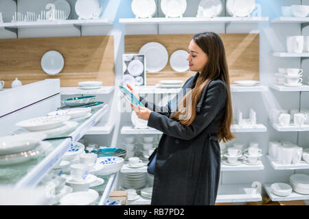Le choix des plats ustensile femme dans un magasin supermarché Banque D'Images