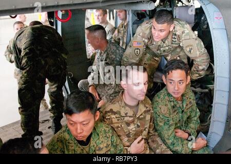 Le Sgt. 1re classe Christopher L. Gauger, un sergent de l'équipe des affaires civiles avec le 412e Bataillon des affaires civiles (Airborne), passe par une répétition d'un saut d'un UH-60 Blackhawk hélicoptère avec l'équipe de saut de Singapour lors de l'opération TOY DROP à Fort Bragg, en Caroline du Nord, le 7 décembre. Gauger, un résident de Columbus, Ohio, a déclaré qu'il est bon de travailler avec des partenaires étrangers afin qu'il puisse mieux comprendre les aspects culturels ainsi que d'être en mesure de voir comment ils fonctionnent au sein de leurs unités. Banque D'Images