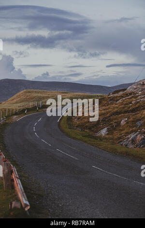 Isle of Harris : an empty road se tordant autour des Hébrides extérieures paysage sur la partie sud de l'îles de Lewis et Harris, Scotland, UK Banque D'Images