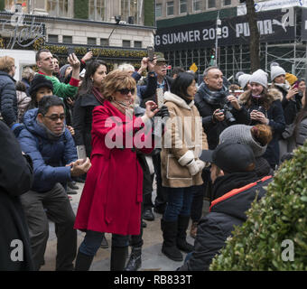 Les touristes avec des téléphones photos de l'arbre de Noël du Rockefeller Center à Midtown Manhattan, New York. Banque D'Images