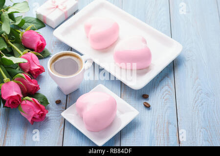 Happy Valentine's day matin avec mousse en forme de coeur des gâteaux, du café, boîte cadeau et fleurs. Banque D'Images