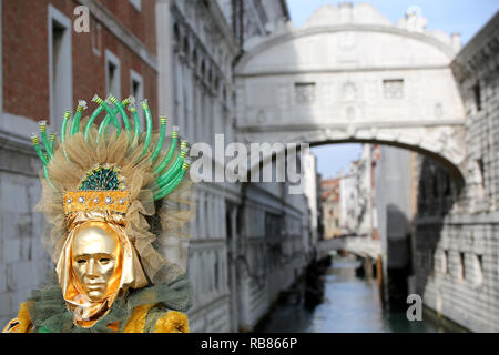 Venezia, VE, Italie - 5 Février 2018 : Personne avec masque d'or et le Pont des Soupirs et du Palais ducal Banque D'Images