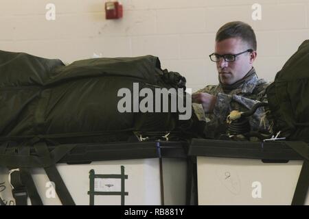 Un arrimeur avec 861e compagnie Quartier-maître, une unité de réserve de Nashville, TN., inspecte un paquet avant de le charger sur un avion, 7 décembre 2016, à l'aérodrome de Fort Campbell, Kentucky. Les soldats du 861e QM Co. s'unir avec les soldats du 74e Transportation Co., d'effectuer la livraison aérienne et le rétablissement de la formation afin d'actualiser leurs compétences. Banque D'Images