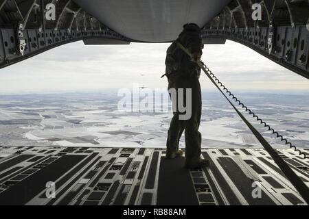 Le s.. Brock Wranik, 62e Escadron de soutien de l'arrimeur, regarde une formation de six C-17 Globmaster III préparer un largage sur Rainier Drop Zone près de Moses Lake, Washington, au cours de l'exercice de guerre Rainier 7 décembre 2016. Le largage de l'un des objectifs remplies de l'exercice, qui a été pour ravitailler les membres de la 7 Division d'infanterie de l'Armée avec l'équipement et des fournitures. Banque D'Images