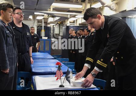 Mer Méditerranée (déc. 8, 2016) - Le Lieutenant Nathaniel C. Calcamuggion met un couvercle sur la table au cours d'une célébration commémorative en l'honneur de l'homonyme, Marine Le Colonel Donald Cook à bord du USS Donald Cook (DDG 75), le 8 décembre 2016 à l'anniversaire de sa mort. Cook, un prisonnier de guerre pendant la guerre du Vietnam a été une inspiration pour ses codétenus de durer et de survivre, de son dévouement à son pays et ses codétenus ont abouti à son attribution à titre posthume de la médaille d'honneur. USS Donald Cook, une classe Arleigh-Burke, missiles de l'avant-déployé à Rota, Espagne, mène Banque D'Images