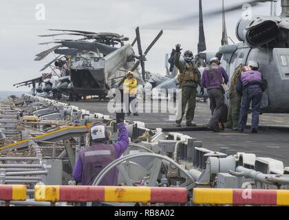 Mer Méditerranée (déc. 8, 2016) Un équipage carburant ravitaille un Sea Hawk MH-60S'hélicoptère sur le pont d'envol du navire d'assaut amphibie USS Wasp LHD (1) le 8 décembre 2016. Le Wasp est déployé avec le groupe amphibie Wasp pour appuyer les opérations de sécurité maritime et les efforts de coopération en matière de sécurité dans le théâtre américain dans la 6ème zone d'opérations de la flotte. Banque D'Images