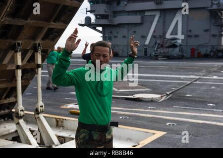 Océan Pacifique (déc. 9, 2016) Seaman Antuan Kelley, de Chicago, agit en tant qu'observateur de la sécurité comme un souffle réacteur déflecteur est soulevée pour l'entretien sur le pont du USS JOHN C. STENNIS (CVN 74). John C. Stennis est en cours d'effectuer un exercice de routine dans la 3ème zone de responsabilité de la flotte. Banque D'Images