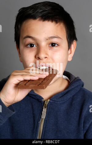 Jeune garçon de 12 ans de manger du chocolat. Paris, France. Banque D'Images