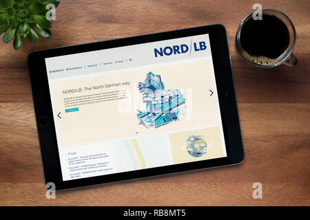 Le site internet de NORD LB bank est vu sur un iPad tablet, sur une table en bois avec une machine à expresso et d'une plante (usage éditorial uniquement). Banque D'Images