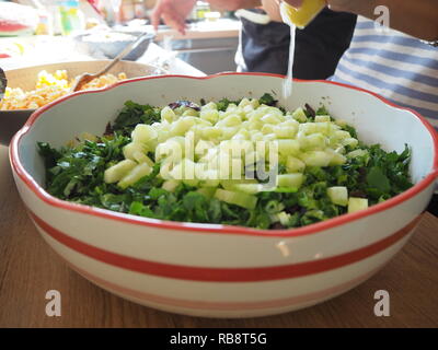 Femme préparant la salade et presser un citron dans la salade. Banque D'Images