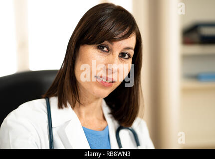 Portrait of smiling female doctor working on laptop in hôpital clinique bureau avec naturel dans les soins professionnels qui réussissent et moi Banque D'Images