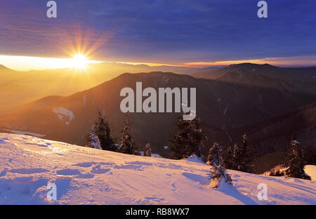 Des montagnes et des forêts à l'hiver avec les rayons du soleil Banque D'Images