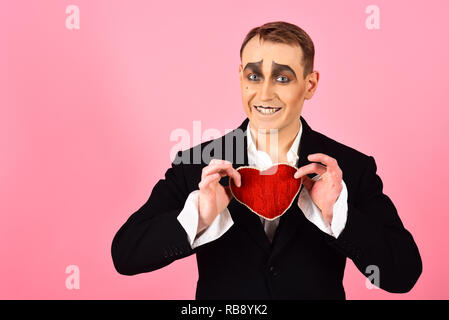 Big hearted. Heureux mime tomber en amour. Homme Mime tenir cœur rouge pour la Saint-Valentin. Acteur mime avec amour symbole. Acteur de théâtre mimant heureux d'émotions. La confession d'amour le jour de Valentines Banque D'Images