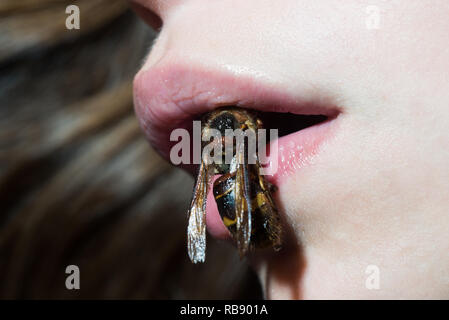 Beauty fashion girl avec abeille sur lèvres. femme avec une peau en bonne santé. levage Miel Abeille gelée royale lait. eco produit. fille avec abeille. resserrement de la peau du visage Lifting. Mascarade Halloween party Banque D'Images