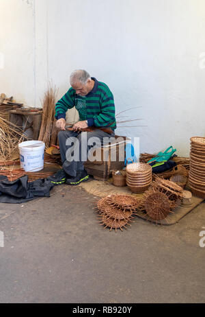 Camacha, Madeira, Portugal - 19 Avril 2018 : un vannier au travail dans le magasin d'usine en Camacha sur l'île de Madère, Portugal Banque D'Images