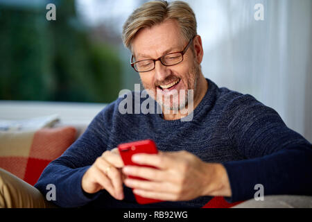L'homme à la détente grâce à son téléphone Banque D'Images