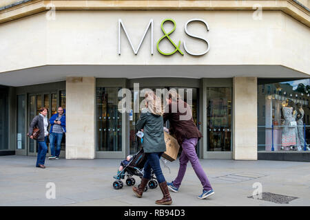 High street Shopping sont illustrés en passant devant un magasin Marks & Spencer shop à Bath, England, UK Banque D'Images