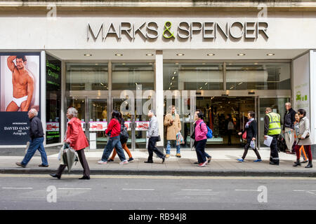 High street Shopping sont illustrés en passant devant un magasin Marks & Spencer shop à Bath, England, UK Banque D'Images