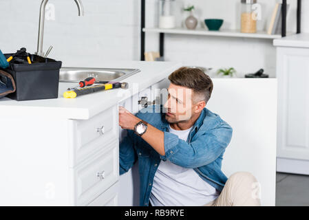 Bel homme la réparation d'évier de cuisine Banque D'Images