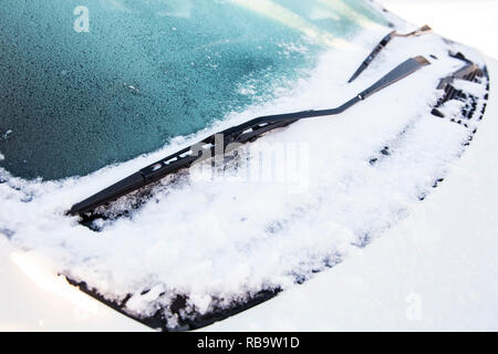 Vue rapprochée d'une voiture ou d'essuie-glaces essuie-sorcière sont gelés et coincé dans la neige et la glace à l'extérieur en hiver. Banque D'Images