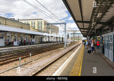 Les passagers qui attendent sur Cambridge station des plates-formes pour des trains sur une journée ensoleillée, Cambridge, Royaume-Uni Banque D'Images