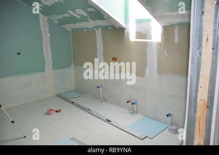 Salle de bains mansardée avec puits en construction avec l'enregistrement de cloison sèche. Banque D'Images