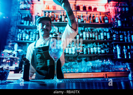 Verre de cocktail Fiery sur le comptoir du bar dans le contexte des barmans mains avec du feu. Concept jour Barman Banque D'Images