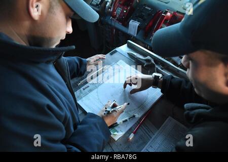 - Mer Méditerranée (déc. 29, 2016) Lt J.G. Enrique Portillo, gauche, maître de Manœuvre des trains 1ère classe Derrick Manzano comment exécuter une carte de manœuvre sur le pont du destroyer lance-missiles USS Porter (DDG 78), le 29 décembre 2016. Porter, l'avant-déployé à Rota, Espagne, mène des opérations navales dans la sixième flotte américaine zone d'opérations à l'appui de la sécurité nationale des États-Unis en Europe. Banque D'Images