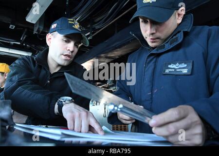 Mer Méditerranée (déc. 29, 2016) Lt J.G. Enrique Portillo, gauche, maître de Manœuvre des trains 1ère classe Derrick Manzano comment exécuter une carte de manœuvre sur le pont du destroyer lance-missiles USS Porter (DDG 78), le 29 décembre 2016. Porter, l'avant-déployé à Rota, Espagne, mène des opérations navales dans la sixième flotte américaine zone d'opérations à l'appui de la sécurité nationale des États-Unis en Europe. Banque D'Images