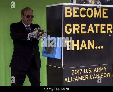 Mark S. Davis, Secrétaire adjoint de l'armée pour le marketing et directeur, Groupe de recherche en marketing de l'armée, affiche l'US Army All-American Bowl (AAB) jeu gants à un photomaton au cours d'une visite de l'armée à l'extérieur de l'expérience Aller San Antonio Alamodome, le 5 janvier dans le cadre des événements qui ont conduit à l'AAB 2017. L'AAB sera diffusé en direct sur NBC Le 7 janvier à 12 h 15 HAC. Banque D'Images
