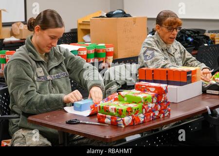 U.S. Air Force Airman Haleigh Hoffman et capitaine principal Sgt. Karla Lewis, tous deux assignés à la 139e Medical Group, New York Air National Guard, envelopper des cadeaux à Rosecrans Air National Guard Base, St., 20 déc., 2018. Les cadeaux ont été achetés par l'Association des chefs de Rosecrans et seront donnés à des industries spécialisées en Saint Joseph. Banque D'Images