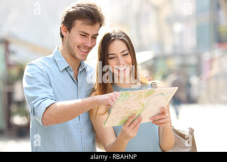 Heureux couple contrôle de carte papier permanent en vacances dans une grande ville street Banque D'Images