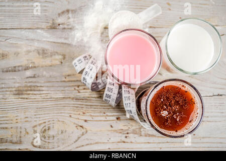 Alimentation boisson biologique sain. Chocolat, Vanille et fruits Boissons protéinées. Protéines laitières non vegan des cocktails. Avec un ruban à mesurer. Concept de los poids Banque D'Images