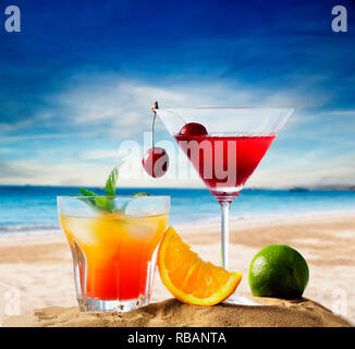Cherry cocktail dans un verre à martini vodka jus d'orange et de la médecine tropicale et plage de sable. Des vacances d'été et les fêtes sur la plage. Banque D'Images