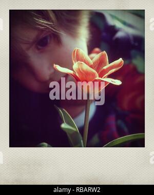 Photographie polaroïd d'une jeune fille par une orange tulip Banque D'Images