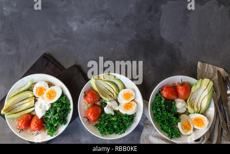 Le quinoa cuit avec des bols de bouddha les tomates, l'avocat, le chou vert, œufs durs et du yaourt grec sur fond de béton gris. Petit déjeuner sain. Vue d'en haut. Copier sp Banque D'Images