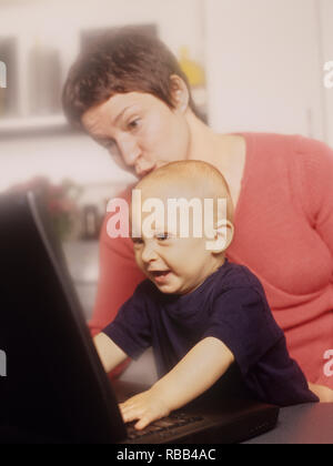 La mère et le petit garçon d'un ordinateur portable avec écran de temps ensemble Banque D'Images