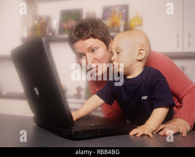 La mère et le petit garçon d'un ordinateur portable avec écran de temps ensemble Banque D'Images