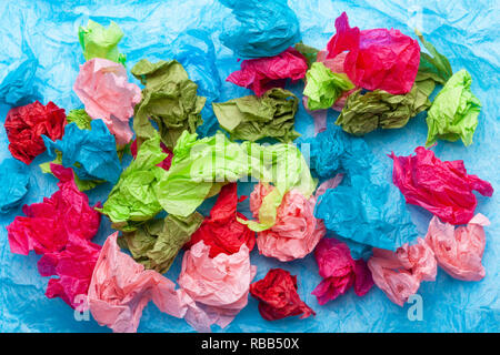 Papier de soie coloré froissé sur un fond de papier de soie bleu Banque D'Images