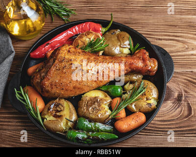 Cuisse de dinde rôtie avec des légumes, les carottes, les poivrons, les pommes de terre les légumes dans une poêle Banque D'Images