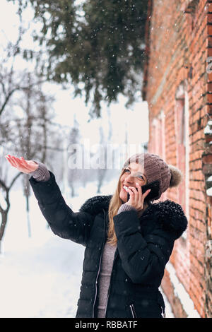 Parlant au téléphone à l'extérieur tandis que la neige qui tombe. Banque D'Images