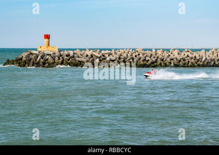 Grand-Fort-Philippe,FRANCE-juillet 18,2017 : scooter avec deux hommes à une grande vitesse à l'embouchure de la rivière L'Aa à la mer du Nord. Banque D'Images