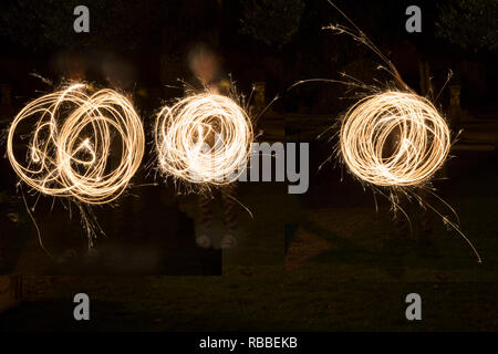 Les étinceleurs être filé autour sur un jour de mariage dans la semi obscurité, par les invités au mariage, les modèles sparkler dans l'obscurité, long exposure Banque D'Images