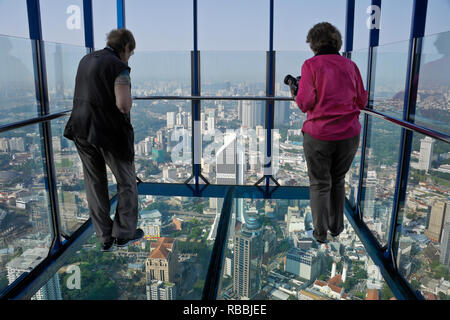 Les touristes debout dans le ciel de verre fort de la KL Tower Sky Deck, Kuala Lumpur, Malaisie Banque D'Images