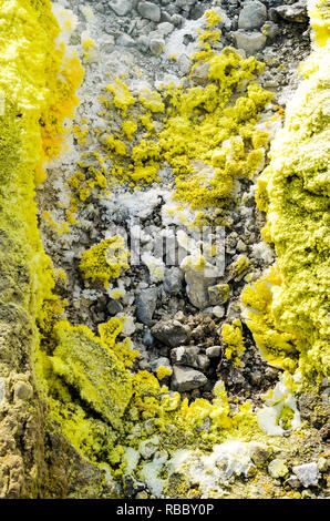 Cristaux de soufre jaune sur les roches de surface d'un cratère de volcan sur l'île de Vulcano, l'archipel des Eoliennes, Sicile. De Gaz, de vapeur et de fumée de fumerolle Banque D'Images