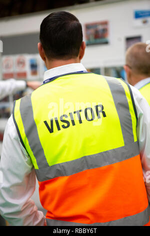Les visiteurs portant des EPI dans une usine de fabrication Banque D'Images
