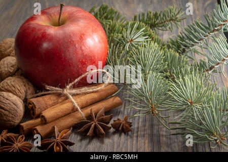 Concept de mise en page de Noël sur fond de bois avec pomme rouge, bande d'anis étoile, la cannelle et le feuillage du pin avec des coquilles de noix communes Banque D'Images