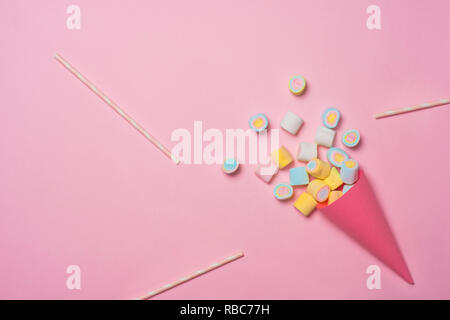 Assortiment coloré bonbons dans un cornet de crème glacée sur fond rose (vue de dessus). Gummy candy variation. Vue d'en haut Banque D'Images