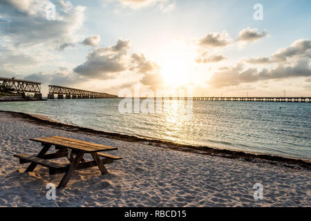 Seven Mile Bridge paysage de Florida Keys reflet de soleil sur l'eau de l'océan atlantique et à l'étranger Route Autoroute à Bahia Honda beach et table de pique-nique Banque D'Images