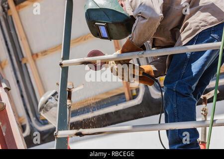 Vue de dessous du travail de soudeur avec Grinder Banque D'Images